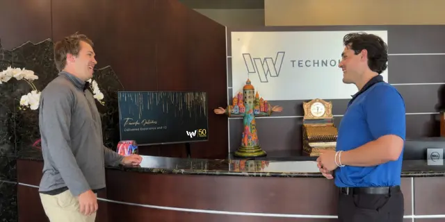 IW employees conversing at front desk